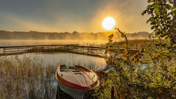 Wrześniowy i mglisty wschód słońca nad jeziorem Mój